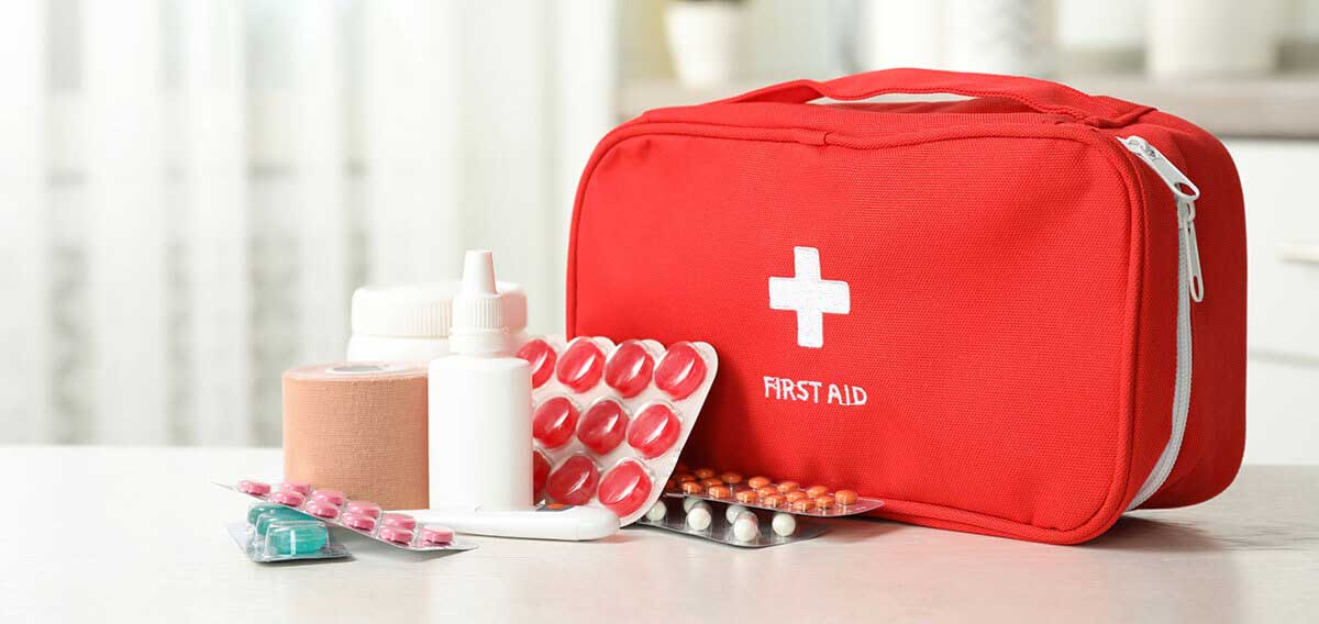 first aid kit with a variety of items laid out in front of it