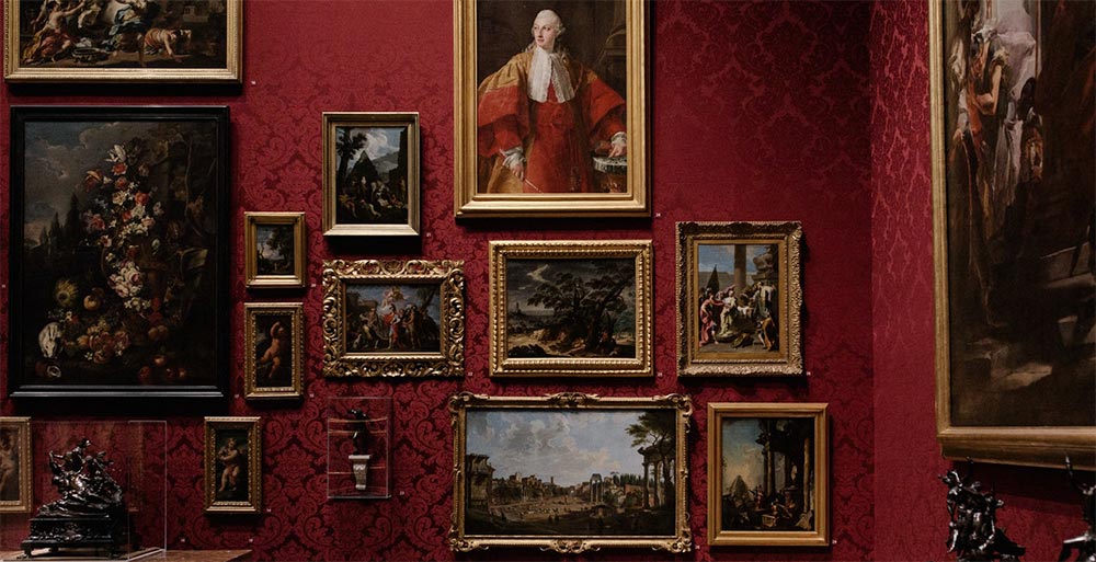Large wall decorated with pictures laid out similar to those in a gallery.