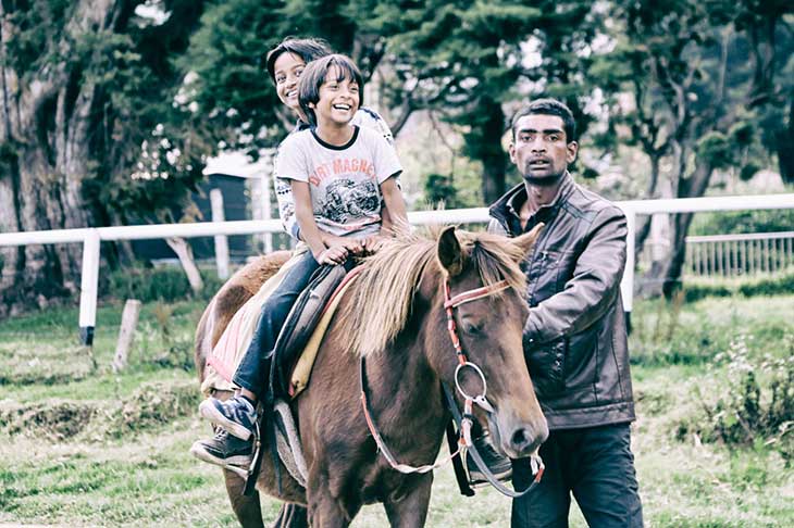 two-children-riding-horse